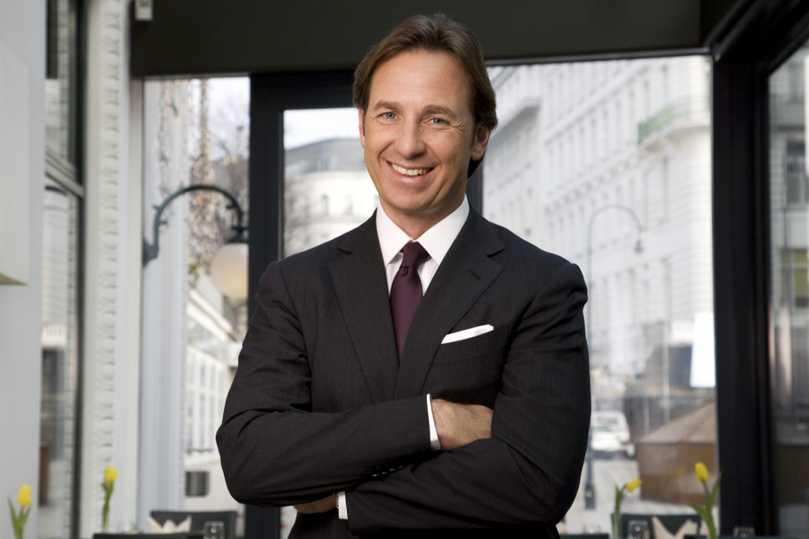 Rustikaler hölzerner Essbereich mit langen Bänken, schräger Decke und hängenden Laternen unter freigelegten Balken.