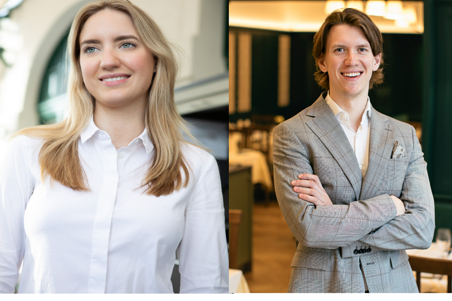 Ein rustikaler, schummriger Pub mit Holzbalken, Fässern, Kronleuchtern und einem gemütlichen Sitzbereich im Obergeschoss.