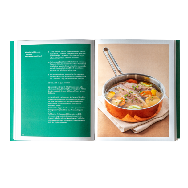 Open cookbook with a recipe on the left and a pot of meat and vegetables in broth on the right.