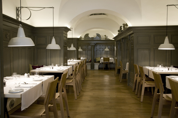 Wooden pergola structure under construction in a garden with gravel and concrete planting beds.