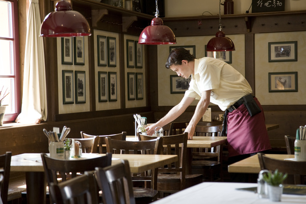 Black and white symbol of a handsaw and a hammer crossed over each other.